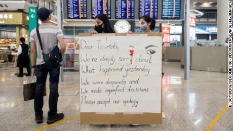 Demonstrators hold a sign at the Hong Kong International Airport in Hong Kong, China, on Wednesday, Aug. 14, 2019.