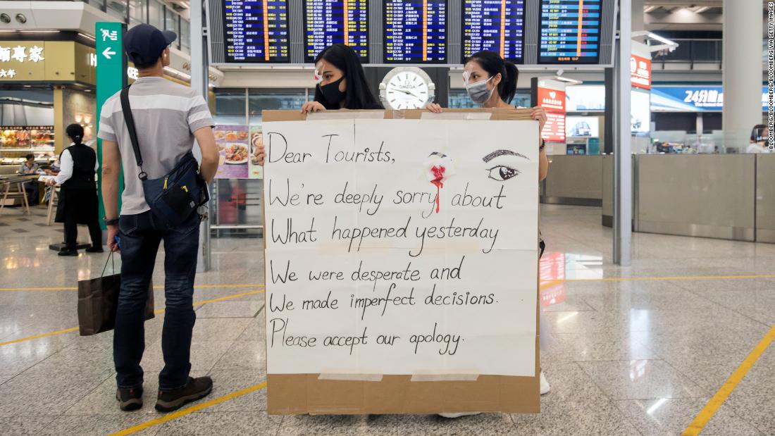 Demonstrators hold a sign at the Hong Kong International Airport in Hong Kong, China, on Wednesday, Aug. 14, 2019.