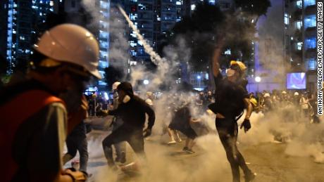 Protesters throw back tear gas fired by the police in Wong Tai Sin during a general strike in Hong Kong on August 5, 2019.