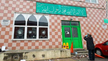 A police forensic officer documents damage to a mosque in Birmingham after several mosques were vandalized in the city in March.