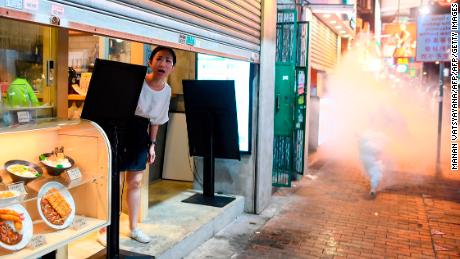 A woman reacts as police personnel fire tear-gas shells to disperse pro-democracy protestors in the Sham Shui Po Area of Hong Kong on August 14, 2019.