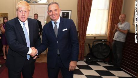 Dominic Cummings is seen in the background (R) on the day Boris Johnson (L) first entered 10 Downing Street as Prime Minister.