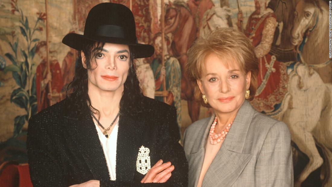 Walters takes a photo with singer Michael Jackson, whom she interviewed in 1997.