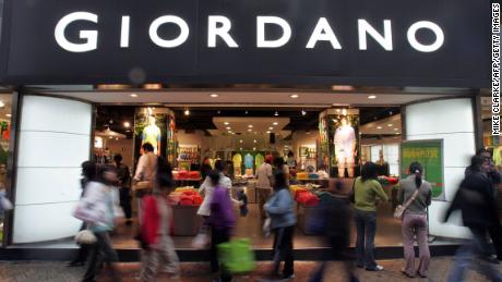 Shoppers pass a Giordano retail store on a rainy day in Hong Kong, 22 March 2005. 