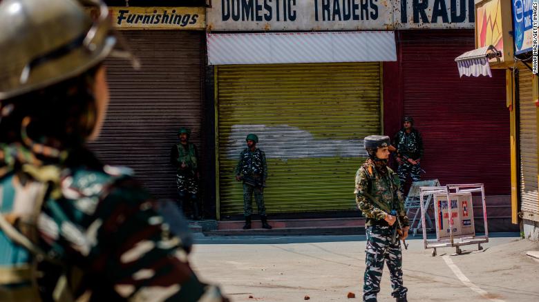  Indian paramilitary troopers stand guard in front the shuttered shops in the deserted city center, on August 20, 2019 in Srinagar.