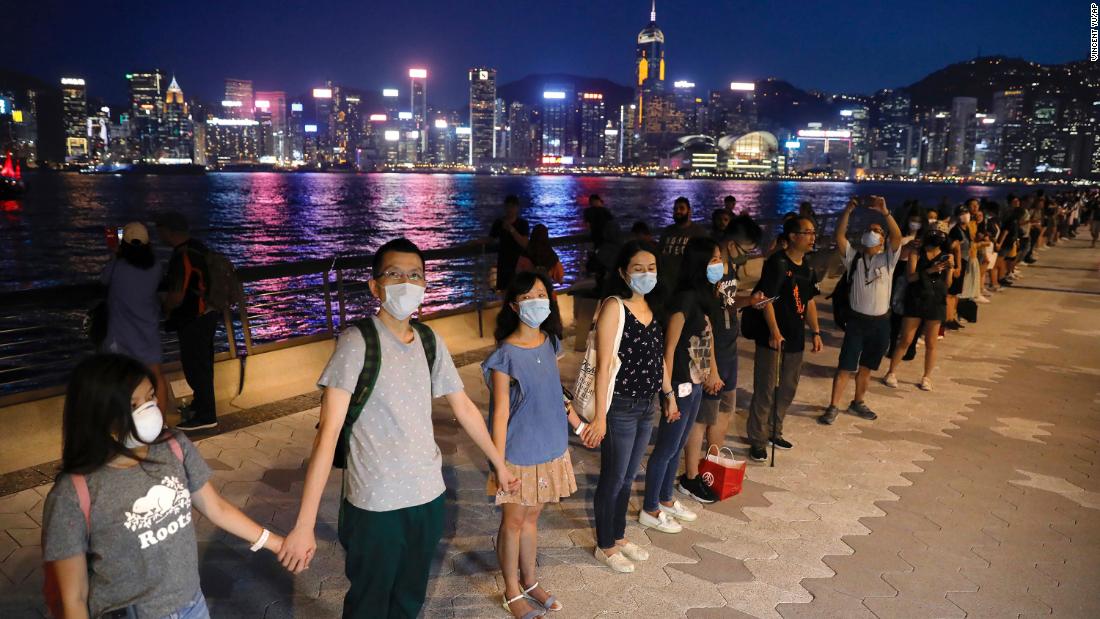 People link hands as they gather at the Tsim Sha Tsui waterfront on Friday, August 23. Protesters formed a human chain across Hong Kong in a show of solidarity.