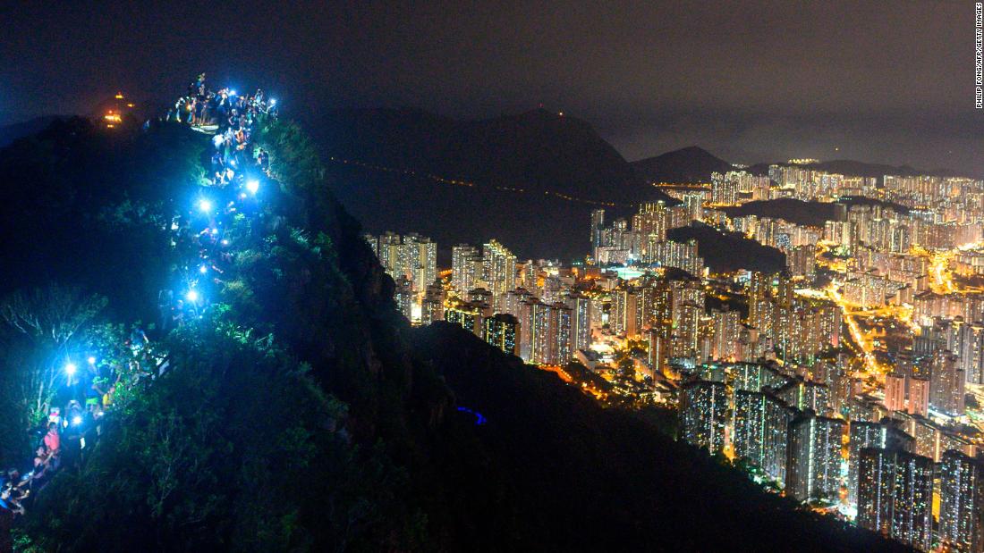 Cell phones shine from the top of Lion Rock on August 23.