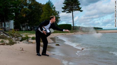 Kyle Haines tosses his husband&#39;s ashes into the water at a location they frequently visited together in Mackinaw City, Michigan.