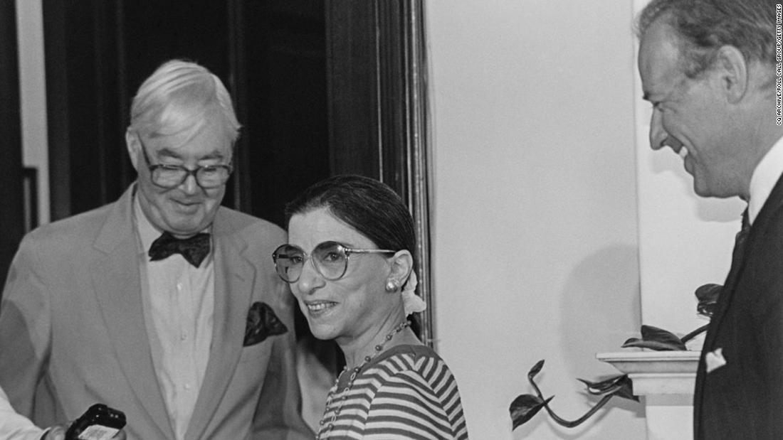 Ginsburg talks with a reporter after being nominated for the Supreme Court in 1993. On the far right is US Sen. Joe Biden. US Sen. Daniel Patrick Moynihan is wearing the bowtie.