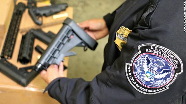 A CBP officer holds one of the seized firearms parts.