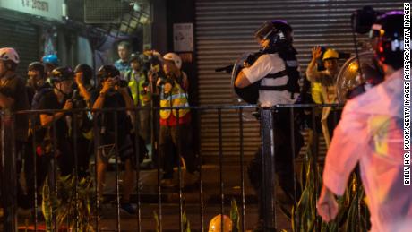 A Hong Kong city police officers points a gun as clashes between pro-democracy protestors and police escalated on Sunday evening.  