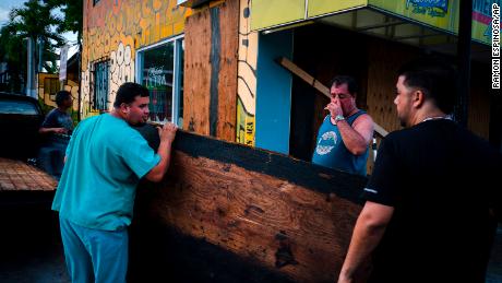 Men board up a shop&#39;s windows ahead of the arrival of Tropical Storm Dorian in Boqueron, Puerto Rico.