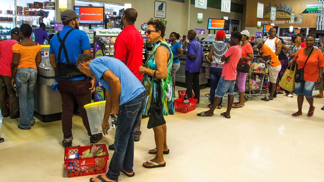 Residents stand in line at a grocery store in Bridgetown on August 26.