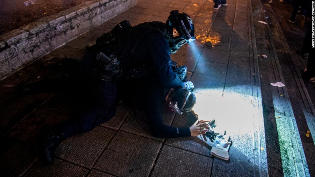 A police officer from the Special Tactical Squad, nicknamed the "raptors," arrests a protester on August 11.