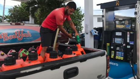 Mathew Cabral fills gas cans before the storm.