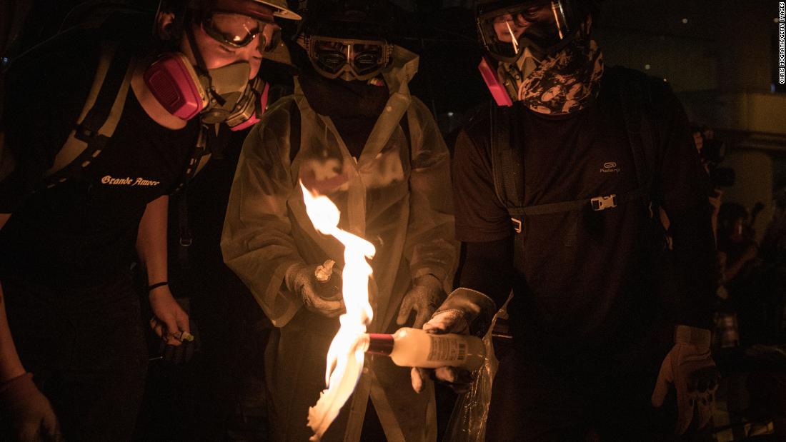 Protesters light a Molotov cocktail after setting a makeshift barricade on fire on August 31.