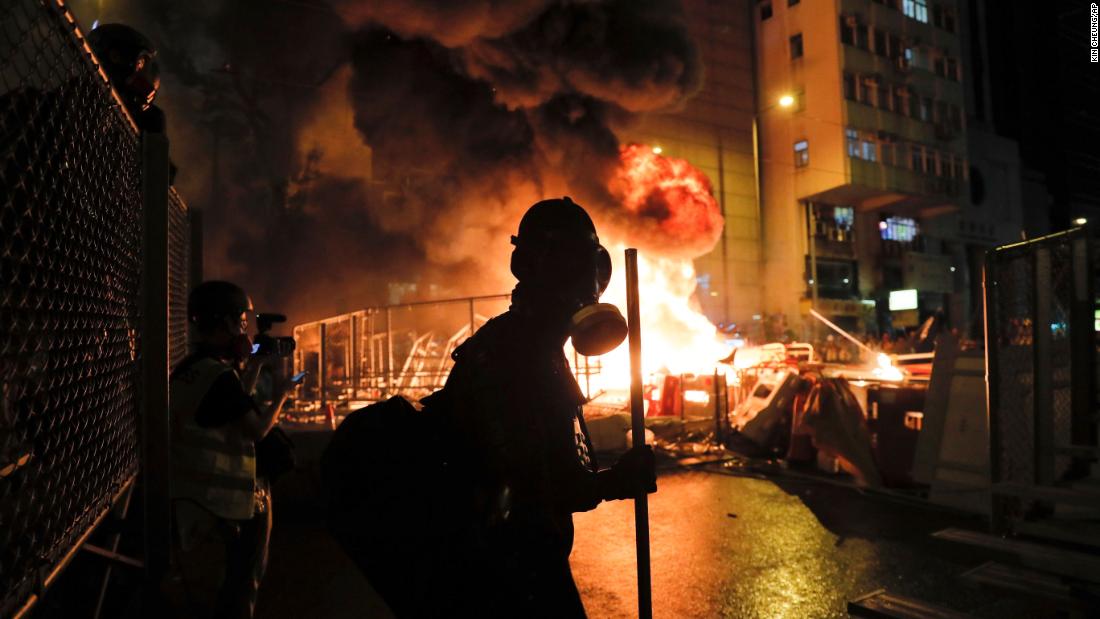 Protesters stand in front of a burning barricade as clashes with the police intensified on August 31.