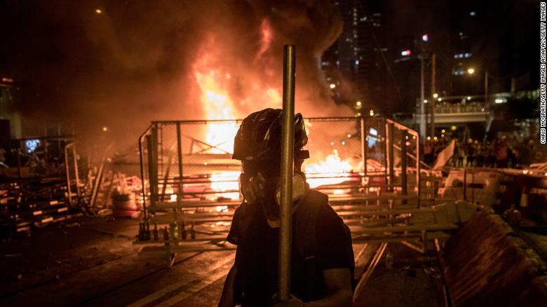 A protesters walks in front of a burning barricade after clashing with police at an anti-government rally on August 31, 2019 in Hong Kong.