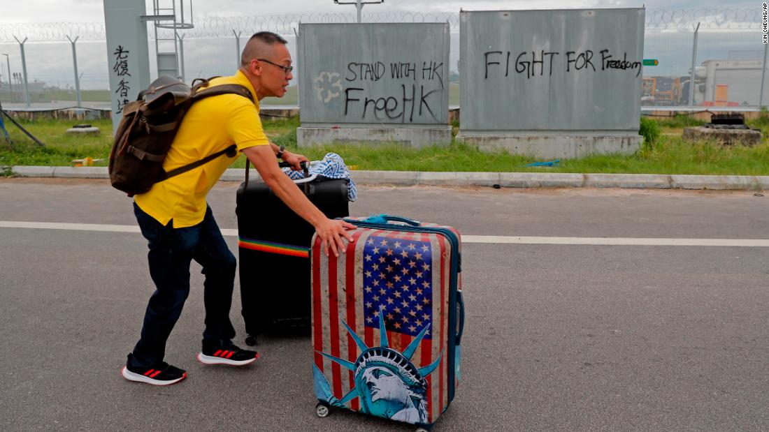 A passenger walks to the airport on September 1 as pro-democracy protesters blocked a road outside the airport.