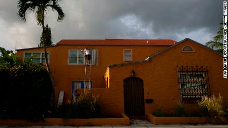 A man places a shutter in a window in Palm Beach County in Lake Worth, Florida on September 1