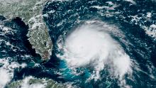 This GOES-16 satellite image taken Sunday, Sept. 1, 2019, at 17:00 UTC and provided by National Oceanic and Atmospheric Administration (NOAA), shows Hurricane Dorian, right, churning over the Atlantic Ocean. Hurricane Dorian struck the northern Bahamas on Sunday as a catastrophic Category 5 storm, its 185 mph winds ripping off roofs and tearing down power lines as hundreds hunkered in schools, churches and other shelters. (NOAA via AP)