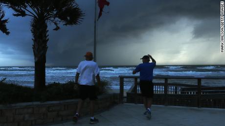 Two men observe an approaching squall caused by Hurricane Dorian on September 3 in Ormond Beach, Florida.