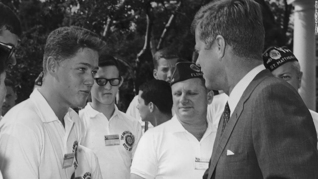 A young Clinton shakes hands with President John F. Kennedy while other American Legion Boys Nation delegates look on during a trip to the White House in 1963.
