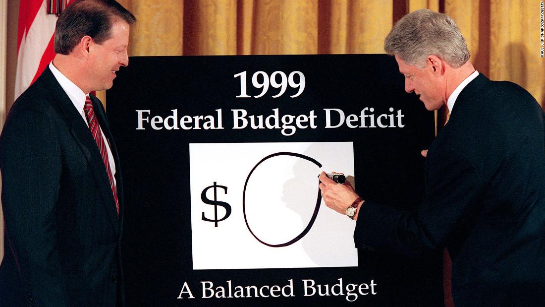 Vice President Al Gore looks on as Clinton writes a &quot;0&quot; on the board, showing what the federal deficit would be after unveiling his balanced budget plan for 1999. The President declared an end to &quot;an era of exploding deficits&quot; as he sent a $1.73 trillion budget to Congress that promised the first surplus in more than three decades.  