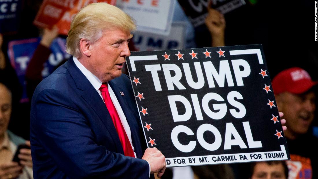 Then-Republican presidential nominee Donald Trump holds a sign supporting coal during a rally in Pennsylvania on October 10, 2016. President Trump's moves to gut greenhouse gas regulations were applauded by many in the fossil fuel industry, but coal jobs continued to decline on his watch.