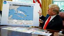 President Donald Trump holds a chart as he talks with reporters after receiving a briefing on Hurricane Dorian in the Oval Office of the White House, Wednesday, September 4, 2019, in Washington. 