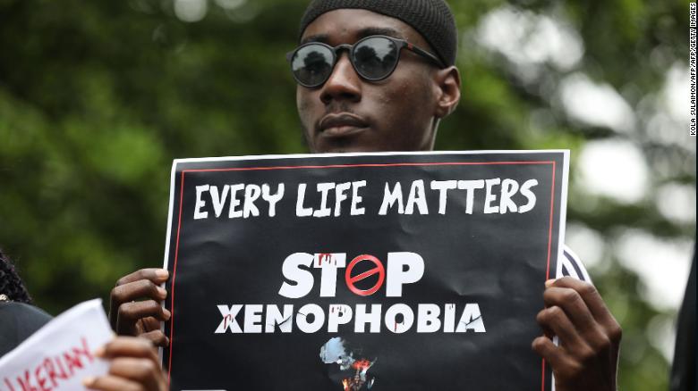 A demonstrator holds a sign during a protest against xenophobia outside of the main gate of the South African High Commission in Abuja, Nigeria.