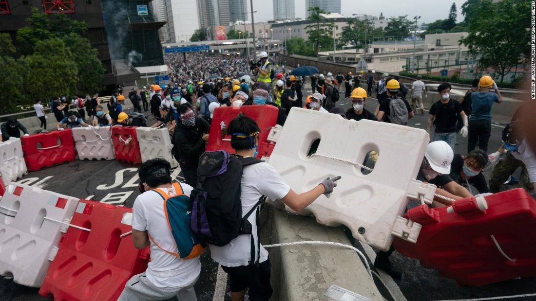 Protesters move barricades to block a street during the June 12 protest.