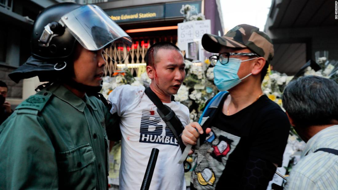 Police escort an injured man after he attacked protesters outside Prince Edward station in Hong Kong on Friday, September 6.