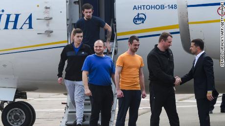 Ukraine&#39;s President Volodymyr Zelensky welcomes former prisoners as they disembark from the plane.