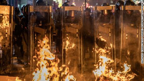 Riot police stand in front a barricade set on fire by protesters after dispersing crowds outside the Mong Kok Police Station on September 7.