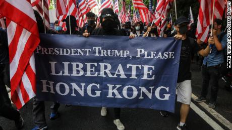 Protesters hold a banner and wave US national flags as they march to the US Consulate in Hong Kong on September 8.