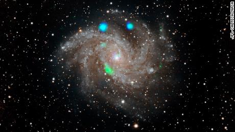 This visible-light image of the Fireworks galaxy (NGC 6946) comes from the Digital Sky Survey, and is overlaid with data from NASA&#39;s NuSTAR observatory (in blue and green).