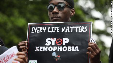 A demonstrator holds a sign during a protest against xenophobia outside South African High Commission in Abuja on September 5, 2019. 