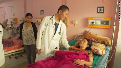 Tshering visits with a patient on hospital rounds.