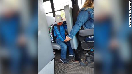 He was nervous about the first day of school, so his school bus driver held his hand for support  