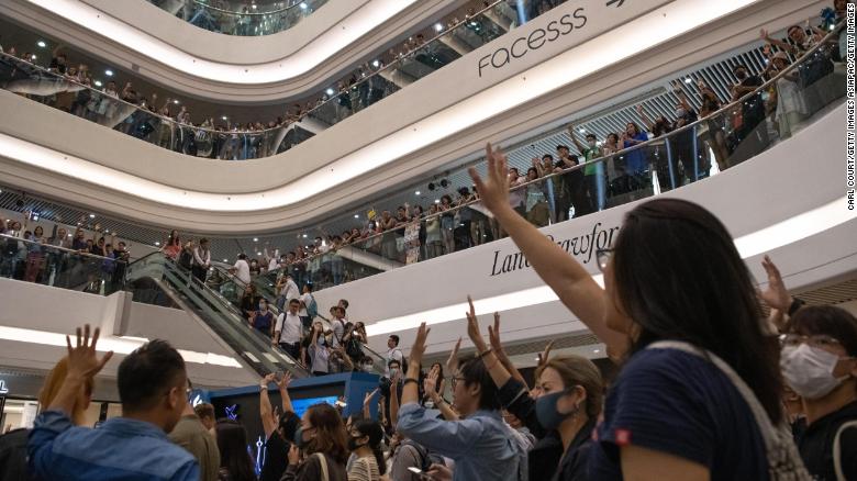 Protesters raise their hands as they sing the Glory to Hong Kong protest &quot;anthem&quot; during a demonstration in Times Square shopping mall on September 12, 2019 in Hong Kong.