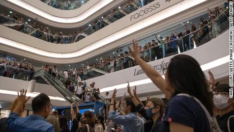 Protesters raise their hands as they sing the Glory to Hong Kong protest &quot;anthem&quot; during a demonstration in Times Square shopping mall on September 12, 2019 in Hong Kong.