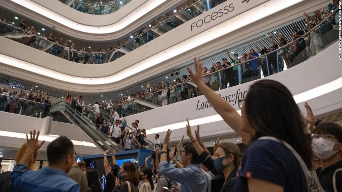 Protesters raise their hands as they sing the Glory to Hong Kong protest "anthem" during a demonstration in Times Square shopping mall on September 12, 2019 in Hong Kong.