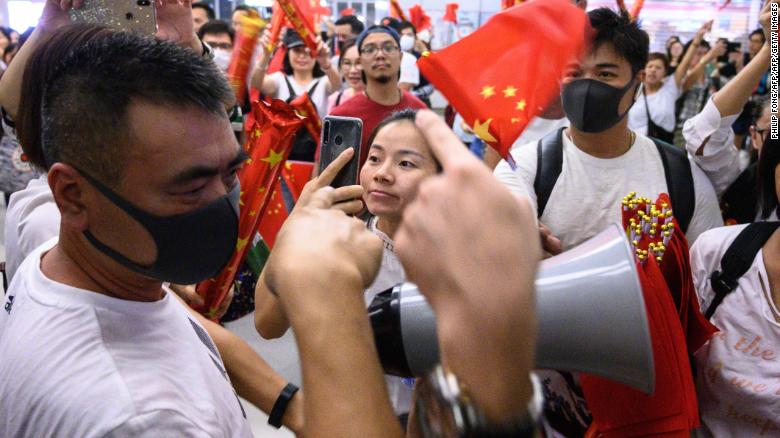 Pro-Beijing counter protesters wave Chinese flags to pro-democracy demonstrators gathering in Yuen Long MTR subway station to attend a singing rally of &#39;Glory to Hong Kong&#39; in a shopping mall in Hong Kong on September 12, 2019. 