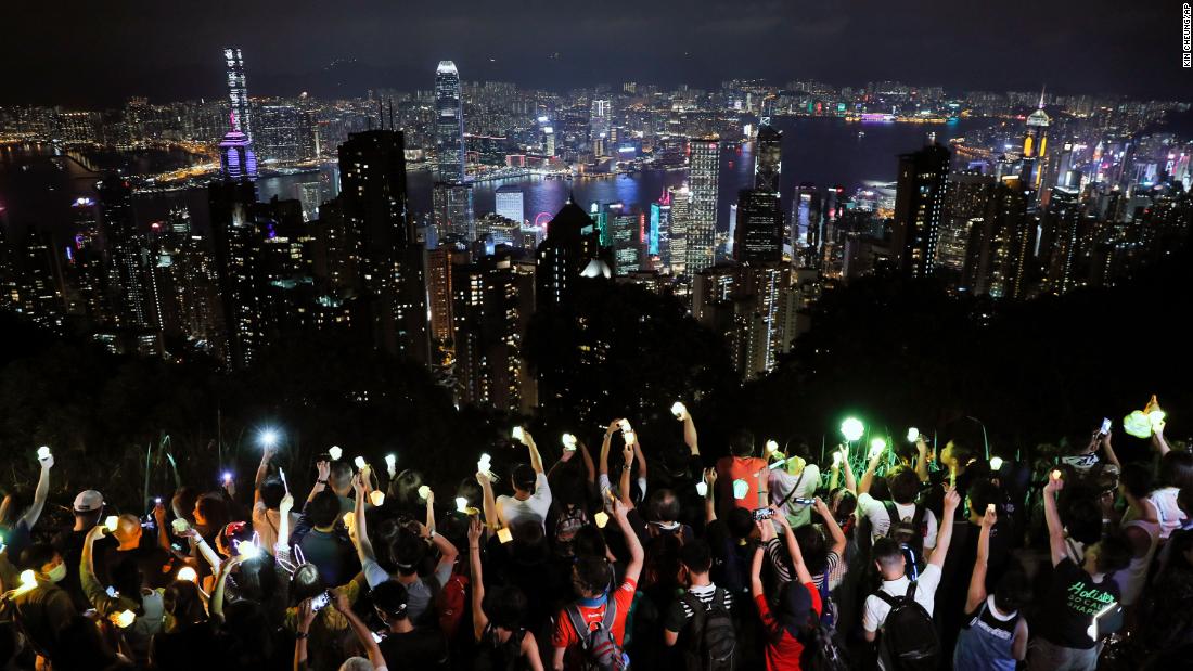 Demonstrators hold up their cell phone lights as they form a human chain at the Peak, a tourist spot in Hong Kong, on September 13.