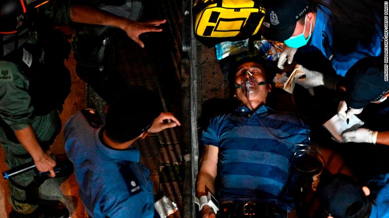 A man is seen to as he lies injured after he was surrounded and beaten on a street in North Point in Hong Kong on September 15, 2019. 