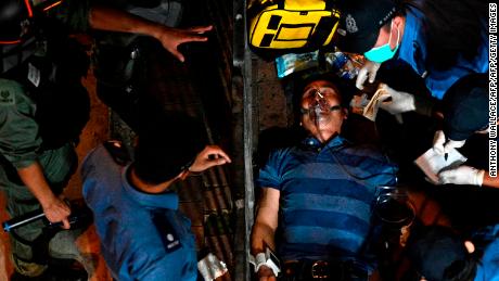 A man is seen to as he lies injured after he was surrounded and beaten on a street in North Point in Hong Kong on September 15, 2019. 