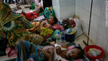 Bangladeshi patients suffering from dengue fever rest on the floor of a hospital ward in Dkaha. 