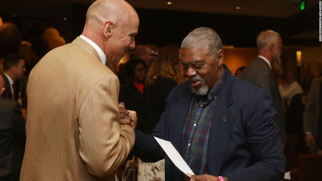 Former University of Wyoming football player Ted Williams grips the hand of athletic director Tom Burman after Williams and the rest of the "Black 14" received a formal apology from the university.