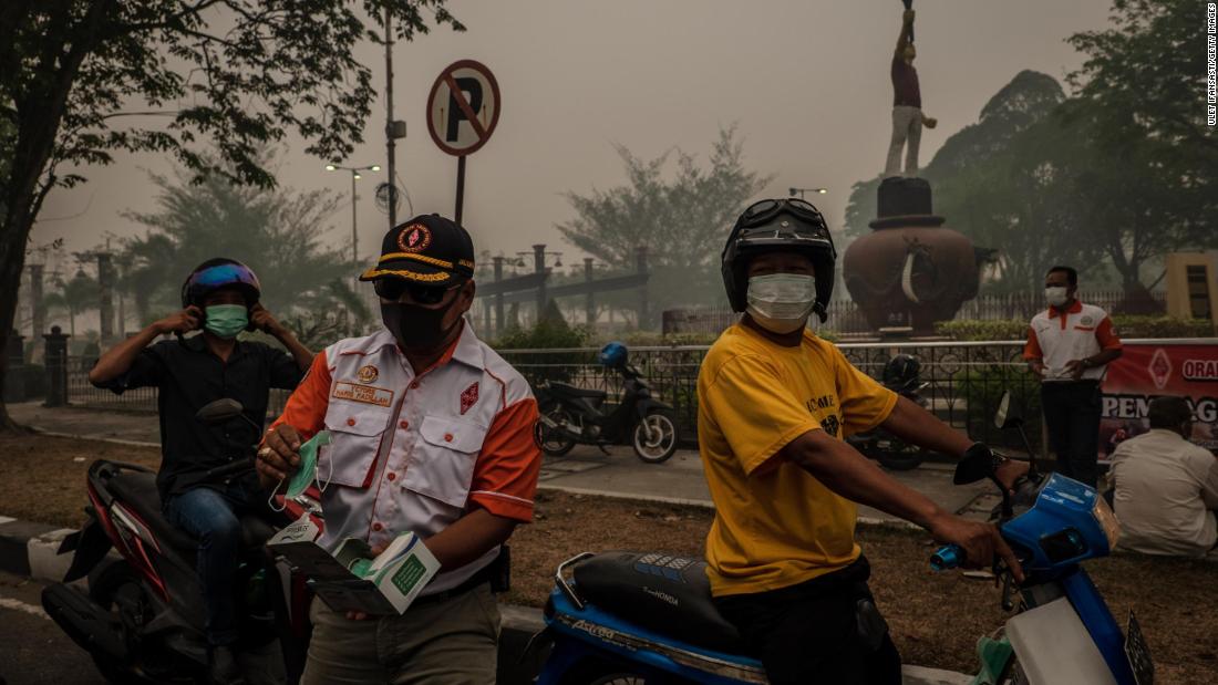 Motorcyclists wear protective masks in Palangkaraya city in Central Kalimantan.